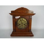 A wood cased mantel clock of architectural form, with key and pendulum.