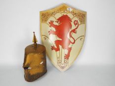 A reproduction knight's helm and shield with rampant lion.