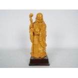 A wooden carving depicting Shou Lao on square section plinth, approximately 23 cm (h).