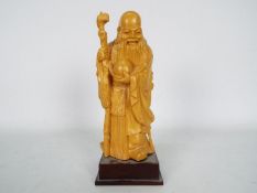 A wooden carving depicting Shou Lao on square section plinth, approximately 23 cm (h).