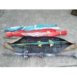A collection of skis and ski poles contained in three ski bags.