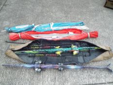 A collection of skis and ski poles contained in three ski bags.