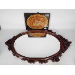 A Chinese hardwood framed mirror, 90 cm x 53 cm and a framed embroidery depicting a Buddhist lion.