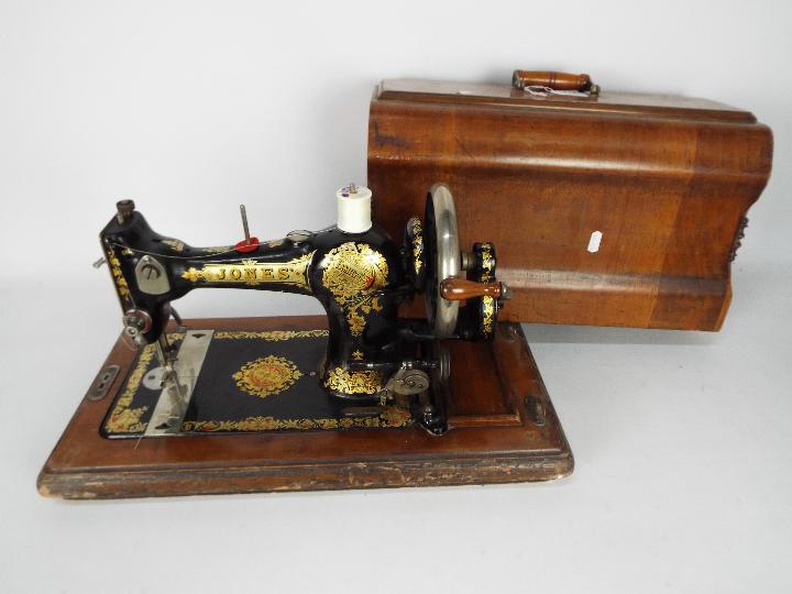A vintage sewing machine in wooden case, Jones Family Cylinder Shuttle.