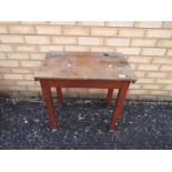 A vintage wooden school desk with hinged top and inkwell recess,