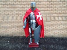 Life size model of a medieval knight's armour, fixed to wooden plinth,