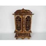 A small, Asian, table top cabinet, intricately carved and with mother of pearl inlay,