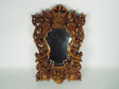 Wall mirror with intricately carved frame depicting dragons, flowers and similar,