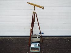 A brass telescope on wood and brass tripod and a vintage portable typewriter.