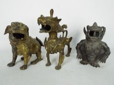 Three Asian cast metal figurines of creatures to include Buddhist lion and similar,