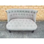 A two seat settee with grey upholstery.
