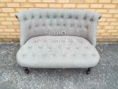 A two seat settee with grey upholstery.