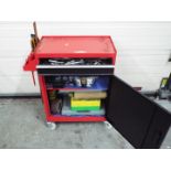 A red metal too cabinet / chest on castors, approximately 73 cm x 61 cm x 29 cm, with contents.