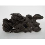 A cast metal Buddhist lion group depicting an adult lion with brocade ball and eight playful cubs,