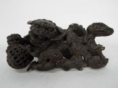 A cast metal Buddhist lion group depicting an adult lion with brocade ball and eight playful cubs,