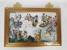 A framed ceramic tile / plaque decorated with numerous figures and auspicious symbols, signed,