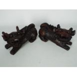 A pair of carved wood Buddhist lions, approximately 11 cm (h).