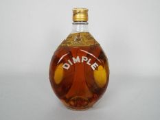 A vintage bottle of Dimple blended Scotch whisky with wire wrapping, no strength or capacity stated.