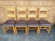 Four modern oak chairs.