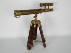 A small brass cased telescope on wood and brass tripod,