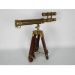 A small brass cased telescope on wood and brass tripod,