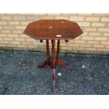 A mahogany, octagonal tilt top occasional table on turned tripod supports,