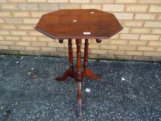 A mahogany, octagonal tilt top occasional table on turned tripod supports,