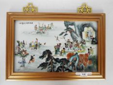 A framed ceramic tile / plaque decorated with numerous figures and auspicious symbols, signed,