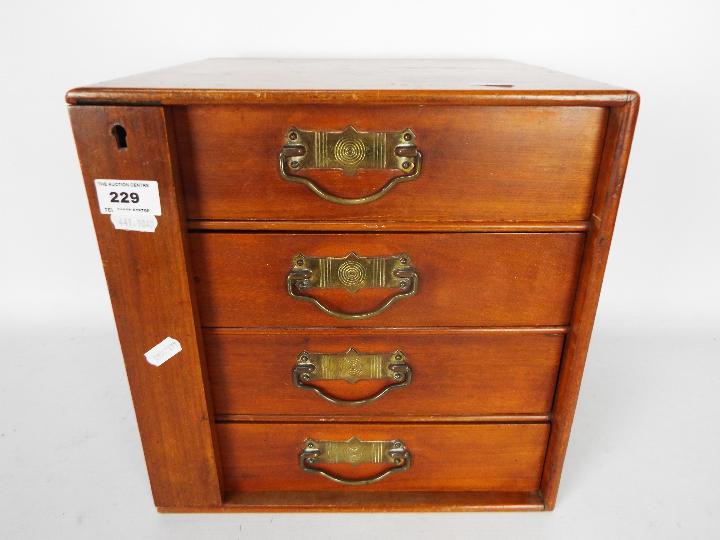 A small four drawer chest / collectors cabinet measuring approximately 31 cm x 30 cm x 26 cm.