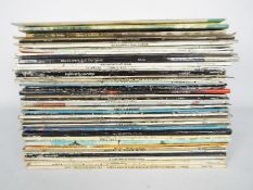 A quantity of 12" vinyl records to include Elton John, George Harrison, The Beatles, Beach Boys,