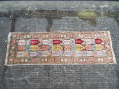 A Chinese silk carpet with a width of 51 cm and length of 158 cm.