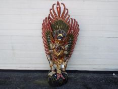 A large Indonesian carved wood and painted figure depicting Garuda, approximately 101 cm (h).