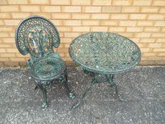 A cast metal garden table and chair.