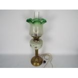A vintage oil lamp (converted) with hand painted reservoir and green tinted glass shade,
