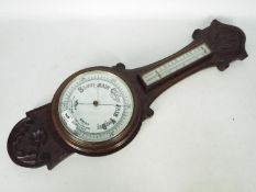 An oak banjo barometer with carved decoration,