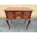 A small sideboard / console table raised on cabriole supports,