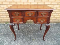 A small sideboard / console table raised on cabriole supports,