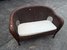 A two seat wicker settee.