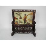 A carved wood table screen with faux jad