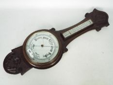 An oak banjo barometer with carved decor