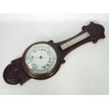 An oak banjo barometer with carved decor