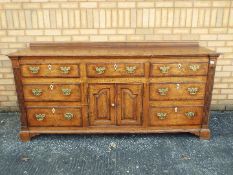 A sideboard with central cupboard flanke