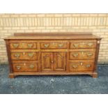 A sideboard with central cupboard flanke