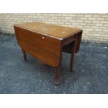 An oak drop leaf table on fluted support