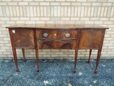 A serpentine front mahogany sideboard wi