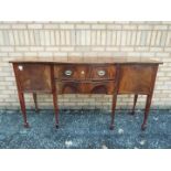 A serpentine front mahogany sideboard wi