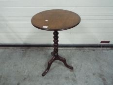 A circular topped side table with bobbin