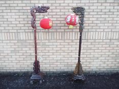 Two wooden standard lamps carved in the