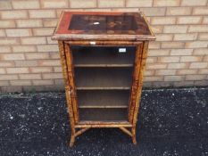 A bamboo framed display cabinet, the top