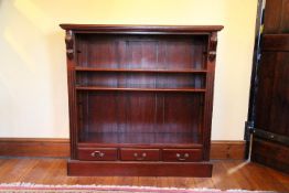 A mahogany open bookcase with carved det